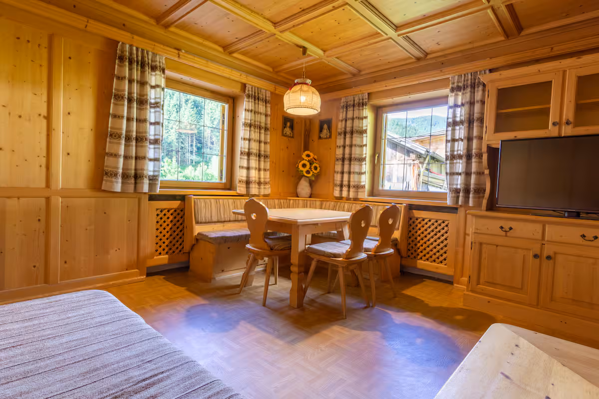 Getäfelte Tiroler Stube mit Eckbank, Holzdecke und original Kachelofen